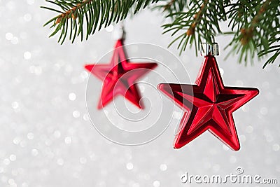 Red christmas stars on the xmas tree on glitter bokeh background. Merry christmas card. Stock Photo