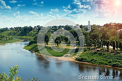 Red church with blue domes from Rzhev town on the shore surrounded by green trees, view from Volga river at sunny summer day Stock Photo