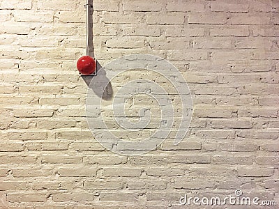 Red circle fire alarm on vintage white brick wall. Stock Photo