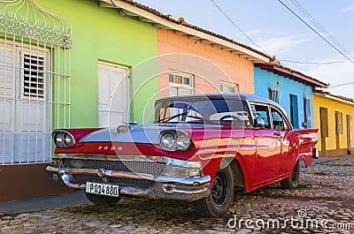 Red classic American car and colorful colonial buildings of Trinidad Editorial Stock Photo