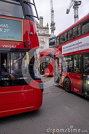 Red classic double decker buses on city road with passengers onboard Editorial Stock Photo