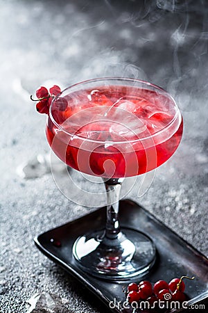 Red cocktail with ice vapor. Cocktail with smoke. Alcohol drink, vodka, ice, party, dry ice. Stock Photo