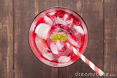 Red Cocktail with mint and ice on wooden table Stock Photo