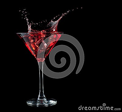 Red cocktail splashing into glass on black Stock Photo