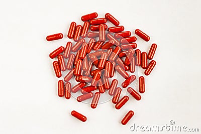 Red capsules pills heap on white background. Medicine pharmacy concept. Close up top view Stock Photo