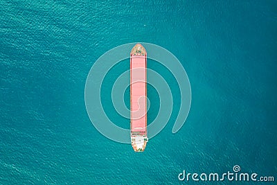 Red color container ship at sea shot from above. Scenic waterscape and lonely boat engaged in export and import business and Stock Photo