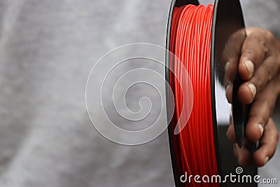 Red 3d printer filament held in hand with space for copy text Stock Photo