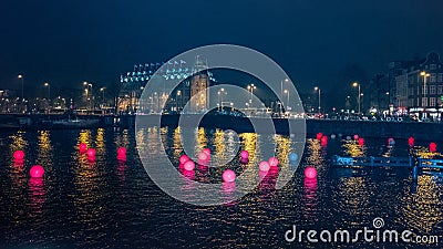 Red colored balls in a canal in Amsterdam in the evening Stock Photo