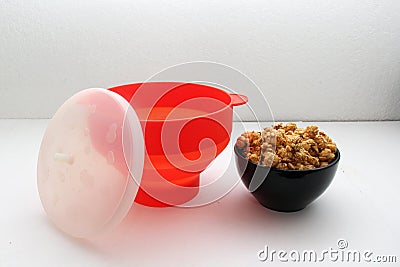 Collapsible red silicone container for microwave popcorn Stock Photo