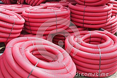 Red corrugated plastic pipes used for underground electrical lines Stock Photo