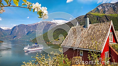 Red cottage against cruise ship in fjord, Flam, Norway Stock Photo