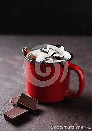 Red cup of aroma hot chocolate with marshmallows and cinnamon on a brown background. Concept cozy drink. Front view and copy Stock Photo