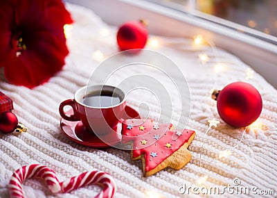 Red cup with espresso coffee and gingerbread in form of fir on white knitted plaid surrounded with winter decor. Stock Photo