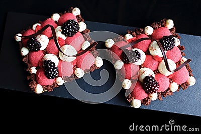 Red currant mousse and blackberry puff pastry desserts with whipped ganache and chocolate spiral decorations, top view Stock Photo