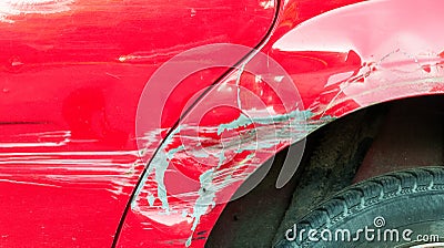 Red damaged car in crash accident with scratched paint and dented metal body Stock Photo