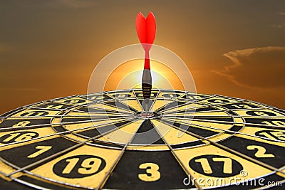 Red dart arrow hitting in the target center of dartboard Stock Photo