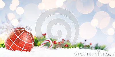 Red decorative ball on the christmas tree on glitter bokeh background with golden twinkle lights Stock Photo