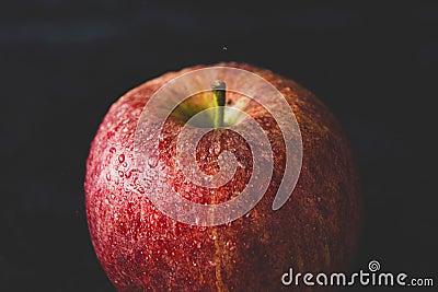 Red delicious apple with water drops, dark moody photo. Abstract fruit background Stock Photo