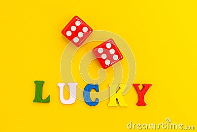 Red dice on a yellow background, the inscription `lucky Stock Photo