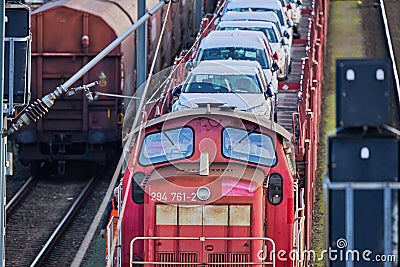 Red diesel locomotive with transport train for cars waiting on the rails for departure Editorial Stock Photo