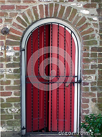 Red Door behind Iron Gate Stock Photo