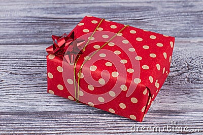 Red dotted gift box on wooden background. Stock Photo