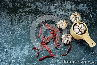 Red dried hot chilli pepper and garlic in wooden spoon on gray background, Chilli and garlic are ingedient of Thai food Stock Photo