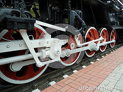 Red driving wheels of a steam locomotive, connected by levers Stock Photo
