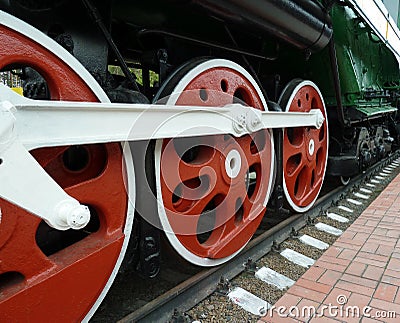 Red driving wheels of a steam locomotive, connected by levers Stock Photo