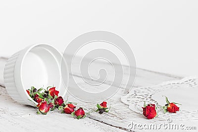 Red dry roses scattered on the light wooden background Stock Photo