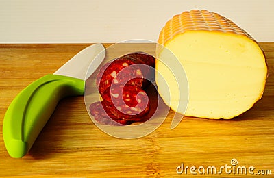 dry red pork sausage slices and cross cut yellow white smoked cheese Stock Photo
