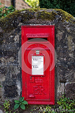 Red English Postbox in Mossy Wall Editorial Stock Photo