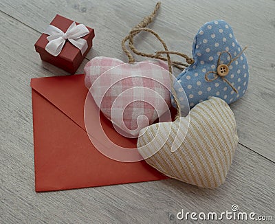 a red envelope made of paper. a gift box with a bow. hearts Stock Photo