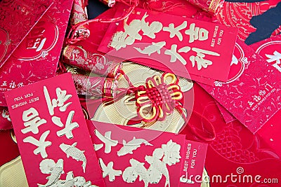 Red envelopes and firecracker ornaments scattered on red spring couplets background Stock Photo