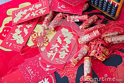 Red envelopes and firecracker ornaments scattered on red spring couplets background.The Chinese character on the red envelope mean Stock Photo