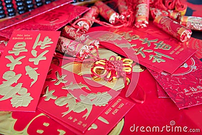Red envelopes and firecracker ornaments scattered on red spring couplets background.The Chinese character on the red envelope mean Stock Photo