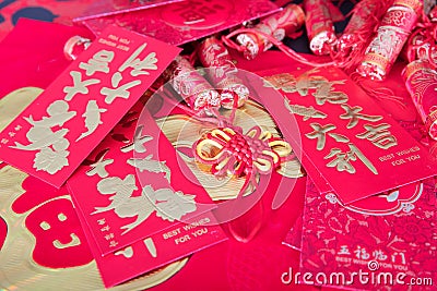 Red envelopes and firecracker ornaments scattered on red spring couplets background.The Chinese character on the red envelope mean Stock Photo