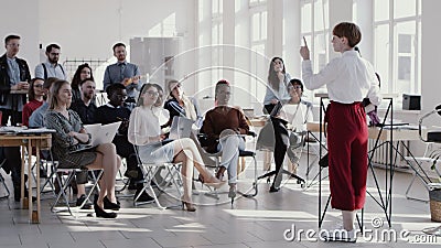 RED EPIC Young short haired business woman giving seminar talk at modern office, multiethnic team clapping slow motion. Stock Photo