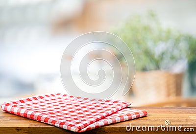 Red fabric,cloth on wood table top on blur kitchen counter roombackground Stock Photo