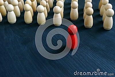 Red figurine in front of line as symbol of leadership. Stand out from the crowd Stock Photo
