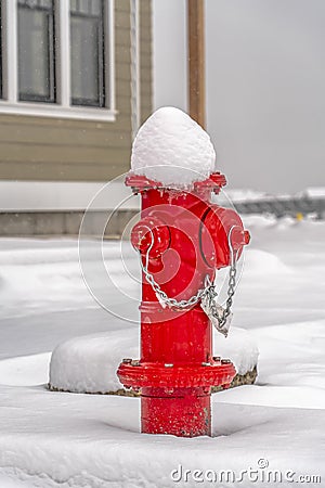 Red fire hydrant on ground with a blanket of snow Stock Photo