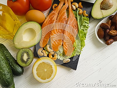 Red fish, avocado, nuts antioxidant lemon protein ingredient on a wooden background Stock Photo