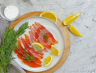 Red fish salted pieces lemon concrete background Stock Photo