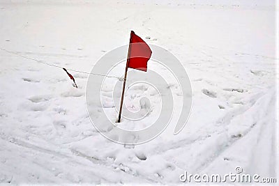Red flag against the background of snow, winter, traces, a Stock Photo