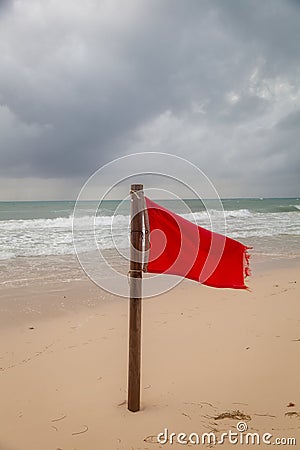 A red flag warning of rough and dangerous surf condition on a beach after a recent hurricane. Stock Photo