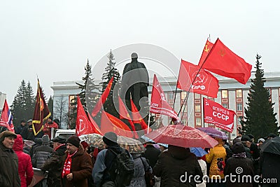 Red flag of Communist party of Ukraine against a monument to Lenin. Editorial Stock Photo