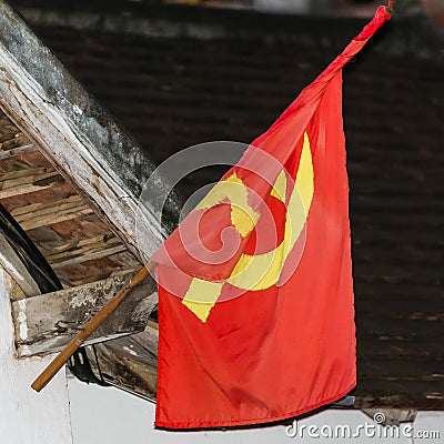 Red flag on the facade of the building, Luang Prabang, Laos. Close-up. Stock Photo
