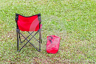 The red folding chair and cover on green grass. Stock Photo