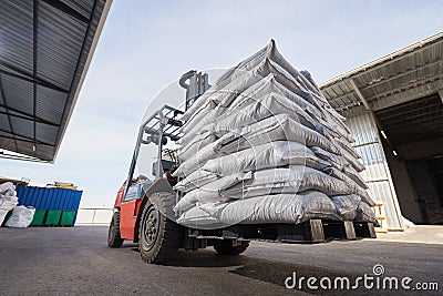 Red forklift lifts pallet with heavy bags Stock Photo