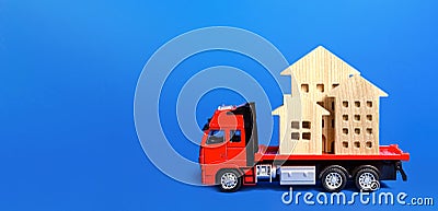 Red freight truck loaded with figure houses. Relocation of buildings and monuments. Cargo transportation, delivery service. A Stock Photo